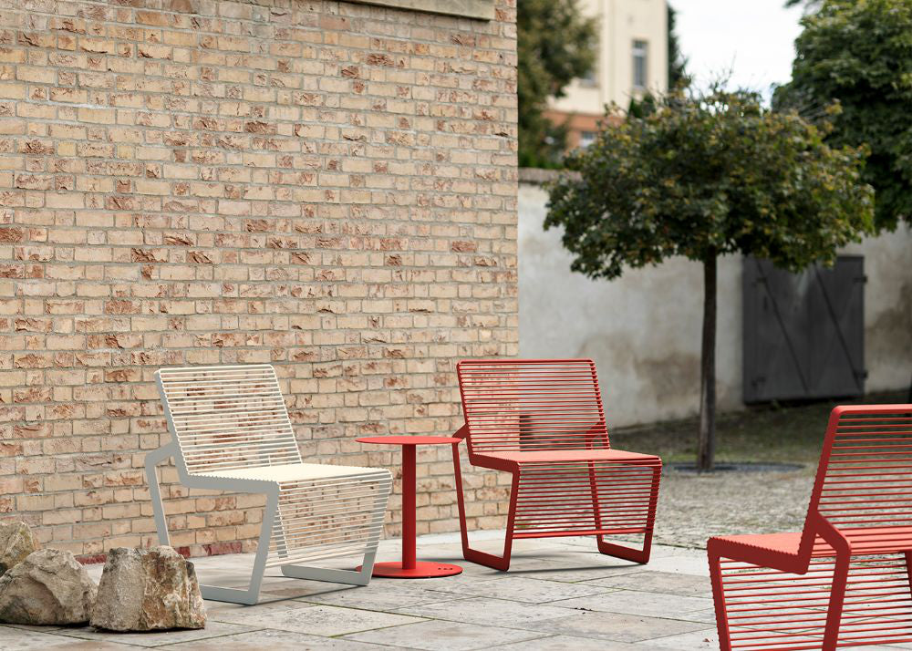 Arne Outdoor Chair with Round Side Table in Outdoor Setting