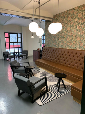 Casper Banquet Seating In Brown Finish With Black Coffee Table And Grey Armchair In Reception Area