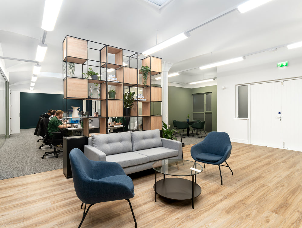 Glass Top Coffee Table With Small Indoor Plant And Lounge Chair In Breakout Setting