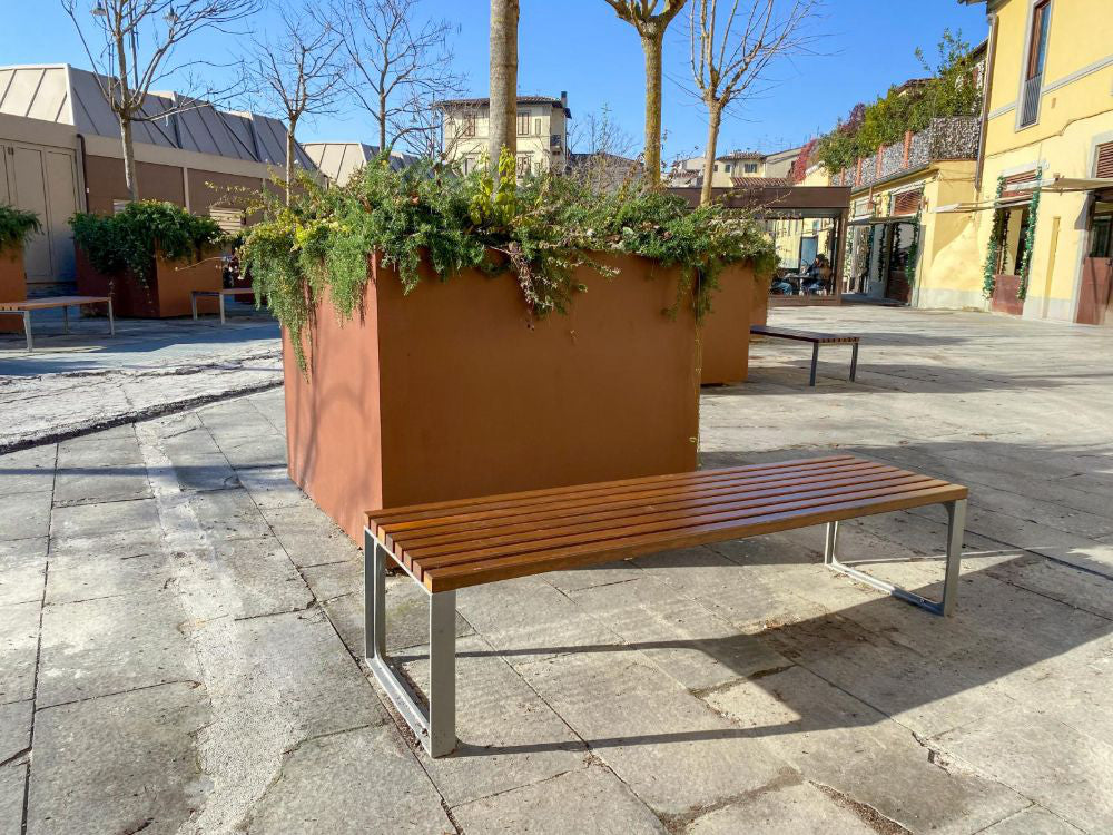 Leman Wooden Backless Outdoor Bench in Brown Finish with Planters in Outdoor Setting