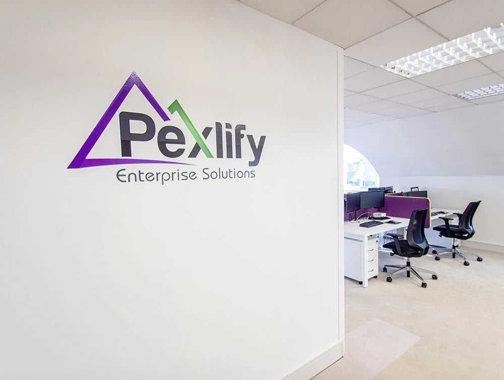 Pexlify Logo On White Wall With Desks In Background
