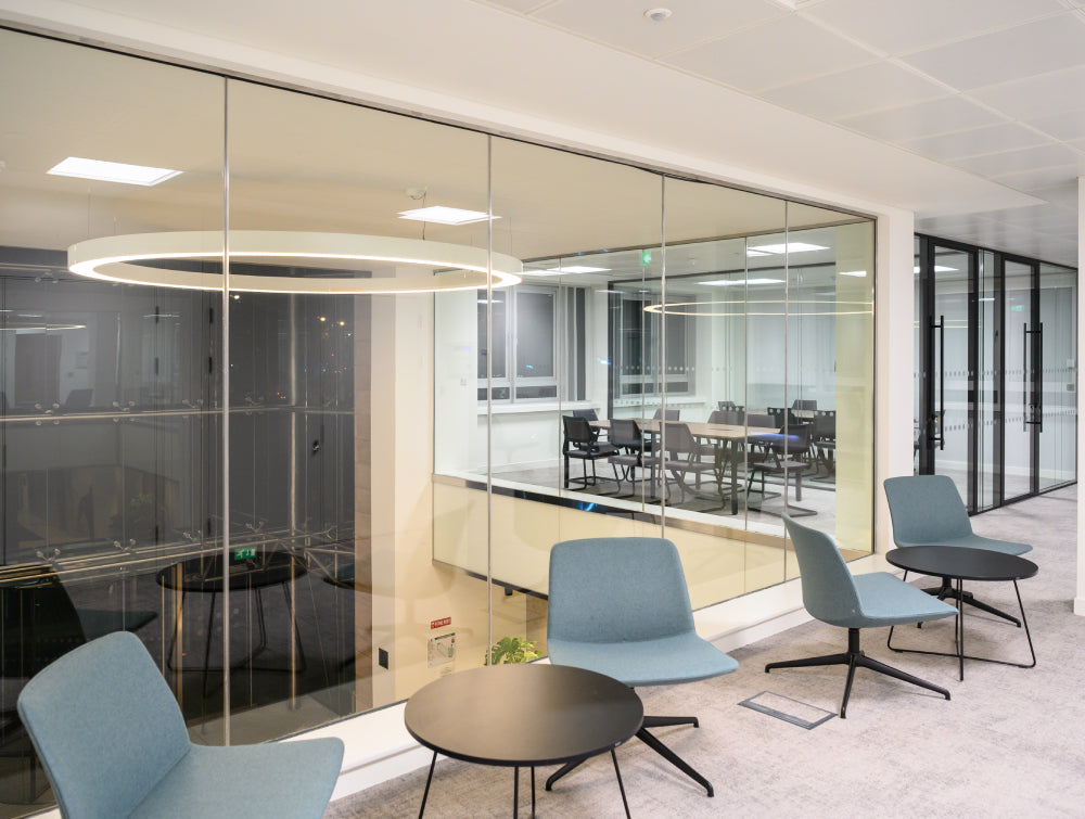 Round Coffee Table In Black Finish With Lounge Chair In Breakout Setting