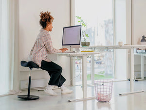 Varier Move Sit Stand Stool 13 In Black Seat Finish With White Adjustable Desk In Modern Office Setting